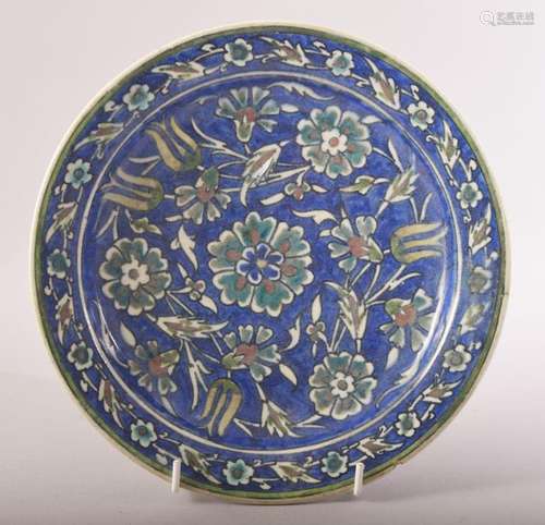 A PALESTINIAN GLAZED POTTERY PLATE, painted with flower head...