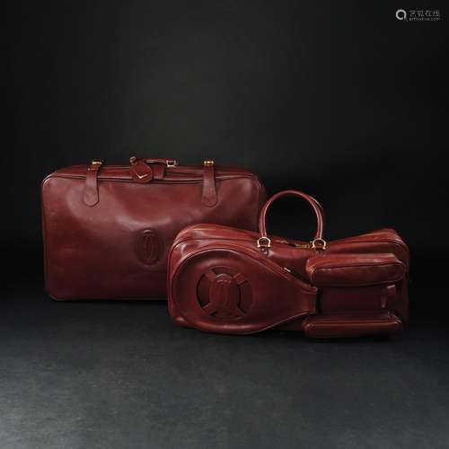 A Les Must de Cartier red leather suitcase and a tennis bag