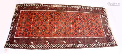 A PERSIAN TEKKE DESIGN RUG, red ground with geometric stylis...
