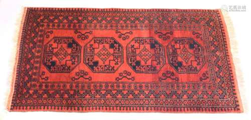 A PERSIAN TEKKE DESIGN RUG, red ground with four large centr...