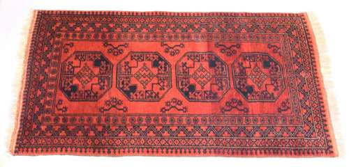 A PERSIAN TEKKE DESIGN RUG, red ground with four large centr...