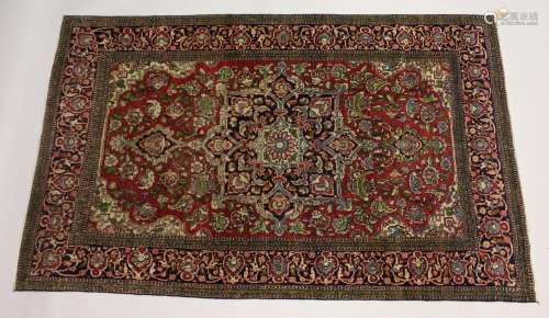 A PERSIAN ISFAHAN RUG, red and blue ground with allover flor...