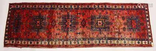 A PERSIAN HERIZ RUNNER, red ground with four large medallion...