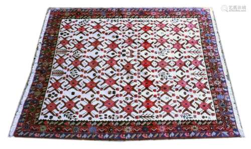 A PERSIAN CARPET, cream ground with stylised red ground meda...