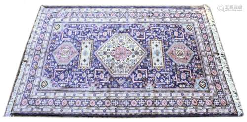 A PERSIAN CARPET, blue ground with a central large cream gro...