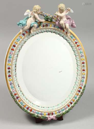 A GOOD MEISSEN OVAL MIRROR with two cupids. Cross swords mar...