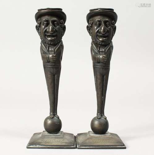 A PAIR OF JUDAICA BRONZE CANDLESTICKS of men, the hat as a c...