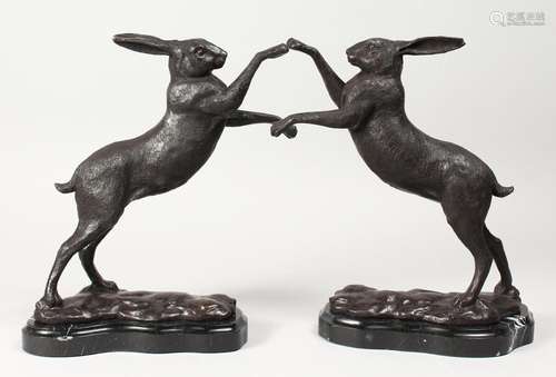 A PAIR OF BRONZE BOXING HARES on shaped marble bases. 11.5in...