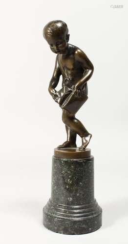 A GOOD BRONZE OF A NUDE YOUNG BOY holding a bag, on a circul...