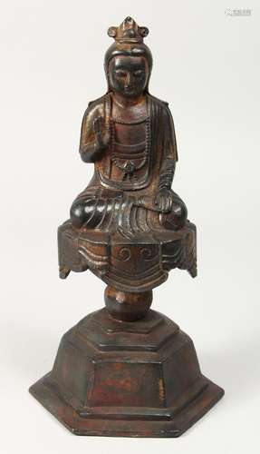 A BRONZE FIGURE OF BUDDHA on a pedestal, one open palm facin...