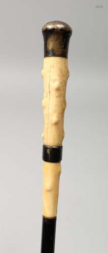 A VICTORIAN BONE HANDLED CANE with silver band and top. 33in...