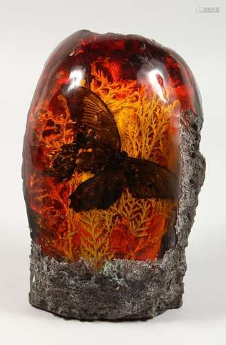 A LARGE AMBER SCULPTURE with a butterfly. 9ins high.