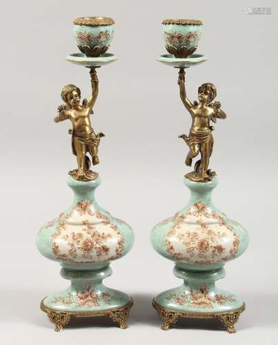 A PAIR OF PORCELAIN AND GILT METAL CHERUB CANDLESTICKS.