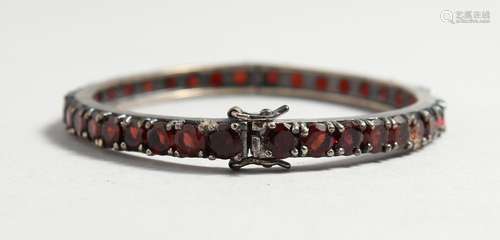 A SILVER GARNET SET BANGLE.