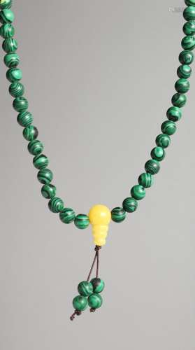 A STRING OF MALACHITE BEADS.