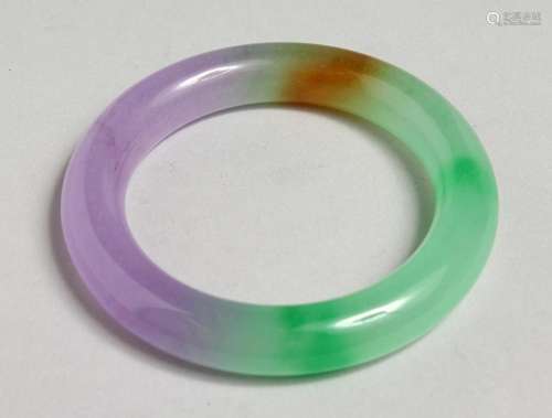 A MULTI-COLOUR JADE BANGLE.