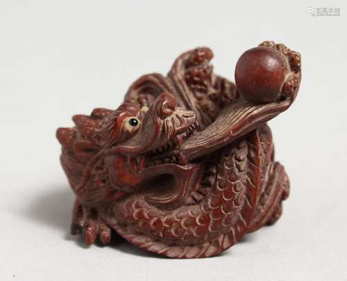 A CARVED JAPANESE WOODEN DRAGON NETSUKE. 1.75ins.