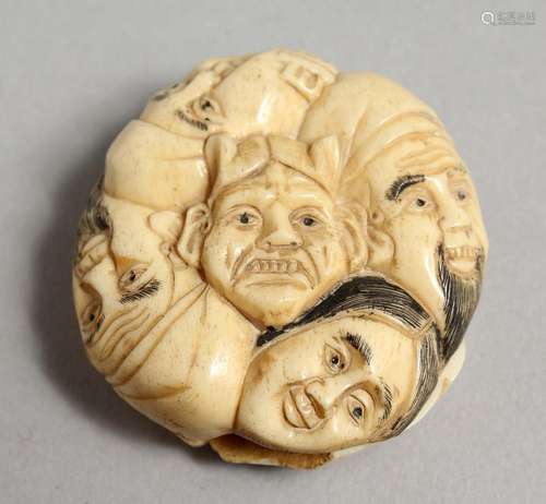 A JAPANESE CARVED BONE FACES NETSUKE. 1.5ins.