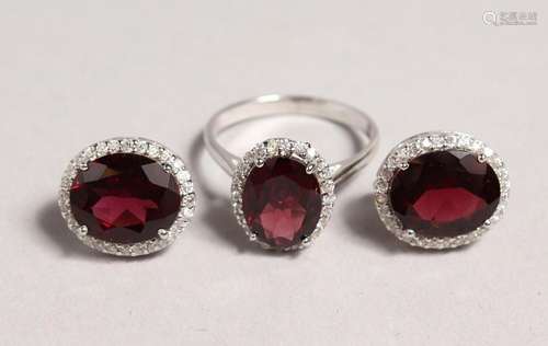 A SILVER AND GARNET RING and MATCHING EARRINGS.