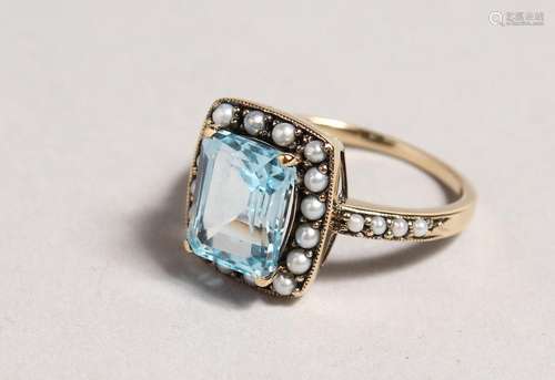 A 9CT GOLD EMERALD CUT BLUE TOPAZ RING.