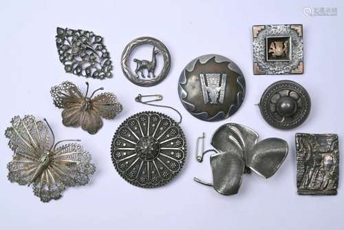 A collection of ten various white metal brooches