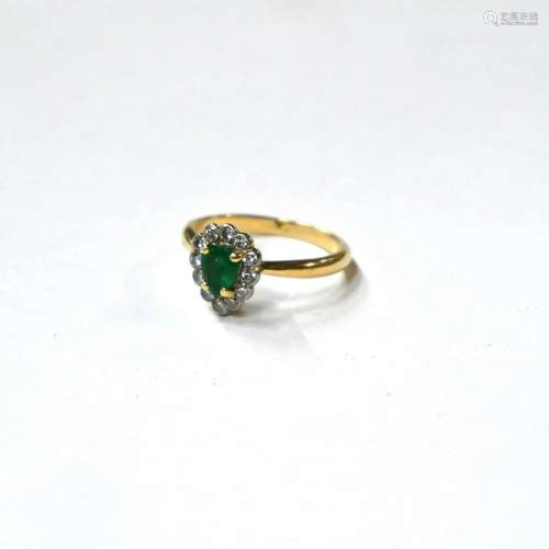 A pear-shaped emerald and diamond cluster ring