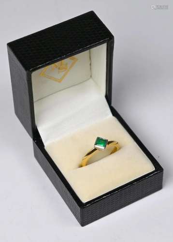 An emerald set single stone ring