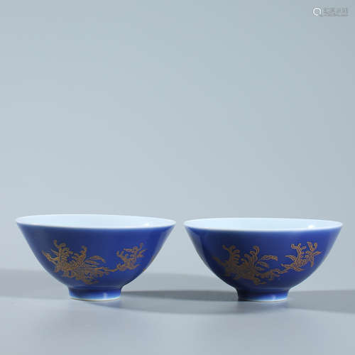 A pair of gold colored cups on a blue background