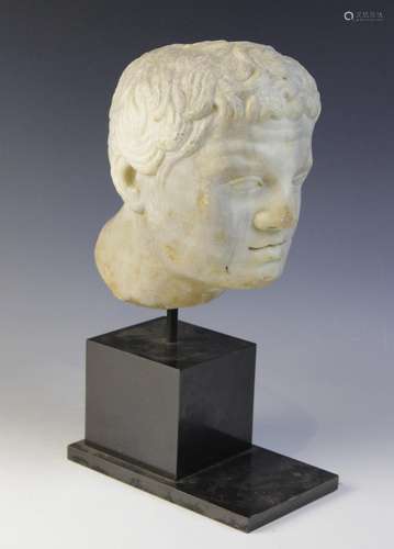 A carved marble male head, in the Roman manner, with curling...