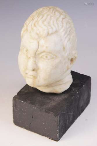 A carved marble head, depicting a young boy with distinctive...