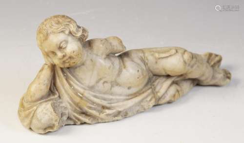 A carved marble fragment depicting a reclining putto with dr...