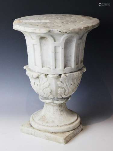 A marble plinth, the urn base with relief carved acanthus le...