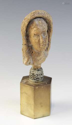 A limestone carved female head depicted wearing a himation p...