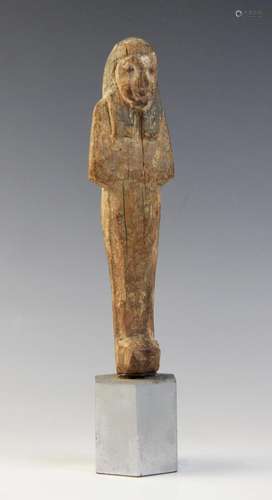 An Egyptian wood shabti, schematically carved with traces of...