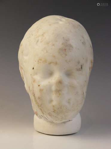 A marble head of a child with heavily worn features, with re...