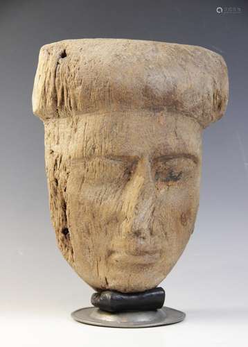 An Egyptian wood sarcophagus mask, traces of the original ge...