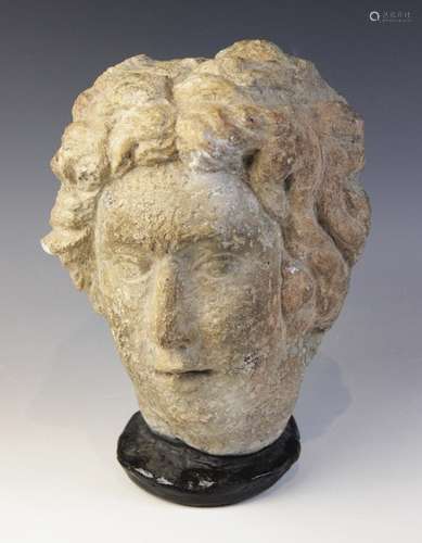 A carved stone female head, in the classical manner, upon la...