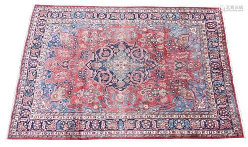 * A Persian pattern wool rug, having a central blue medallio...