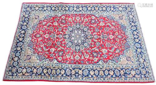 * A large Iranian wool rug, with a traditional blue medallio...