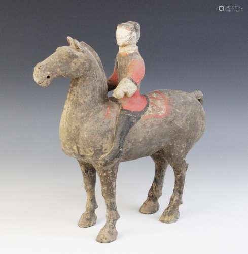 A Chinese pottery model of a figure riding a horse, possibly...