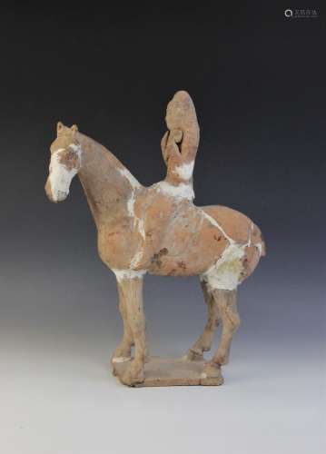 A Chinese pottery model of a figure riding a horse, possibly...
