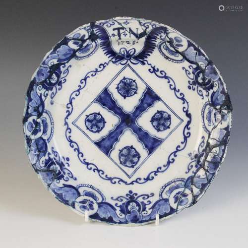 A delft plate dated 1725, blue painted with a central lozeng...