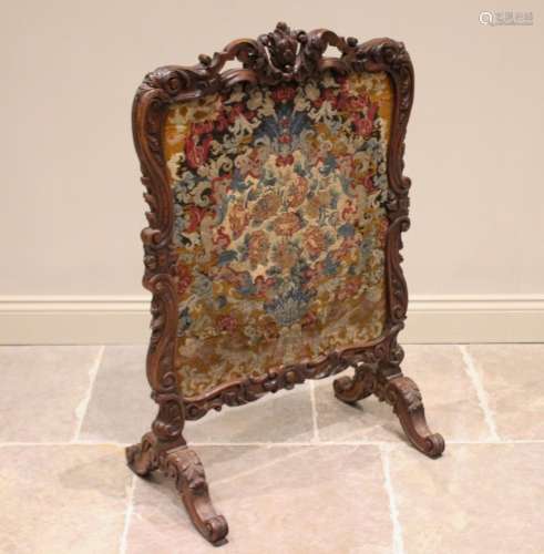* A French walnut fire screen, 19th century, the Rococo leaf...
