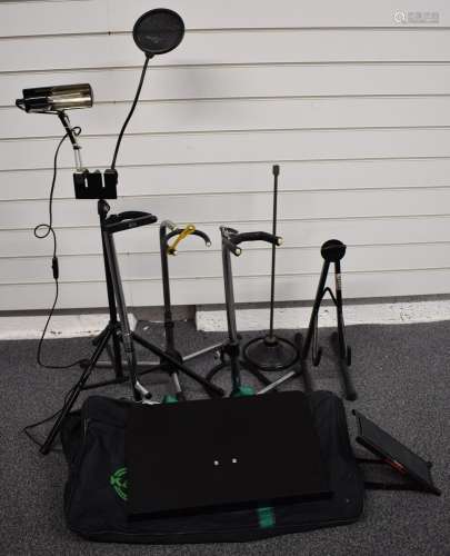 A collection of various microphone and guitar stands, drum s...