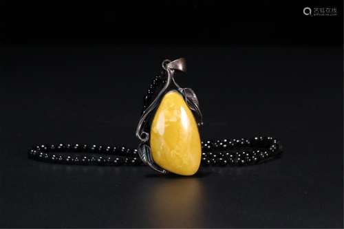 A CHINESE AMBER PENDANT COVERED SILVER