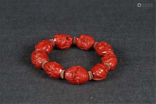 A CHINESE CINNABAR EIGHTEEN LUOHAN BRACELET