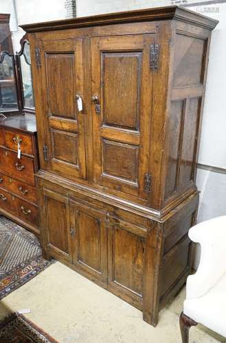 A 17th century style oak press cupboard, with three panelled...