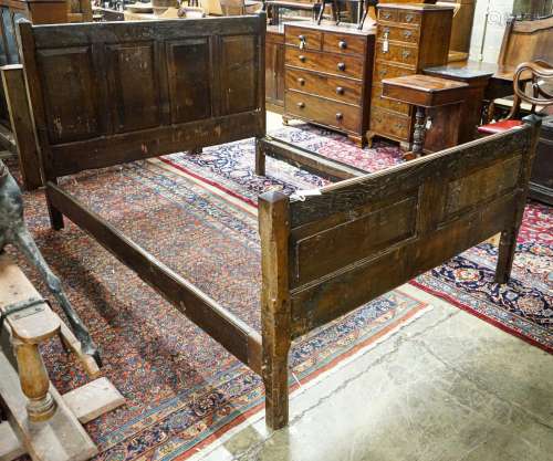 A 17th century style panelled oak bedstead, width 158cm, len...