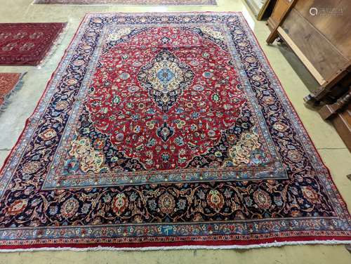 A Kashan burgundy ground carpet, 380 x 300cm