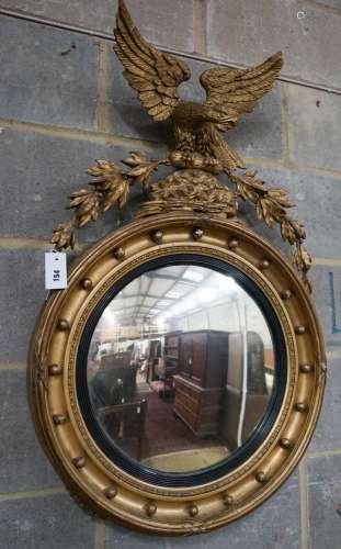 A Regency giltwood and gesso convex wall mirror with eagle p...